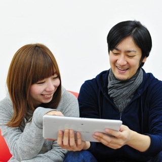 タブレットを見ている男女カップル