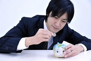 貯金をするスーツ男性