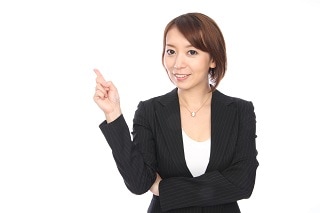 指を立てているスーツ女性