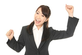 ガッツポーズしているスーツ女性