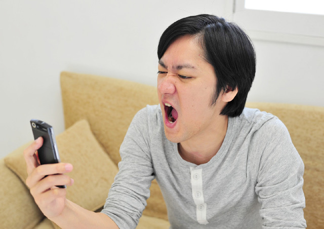 スマホを見てエーっという顔をしている男性