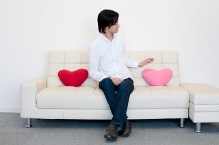 白いソファに座っている男性