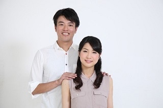 妻の肩を後ろから抱く男性