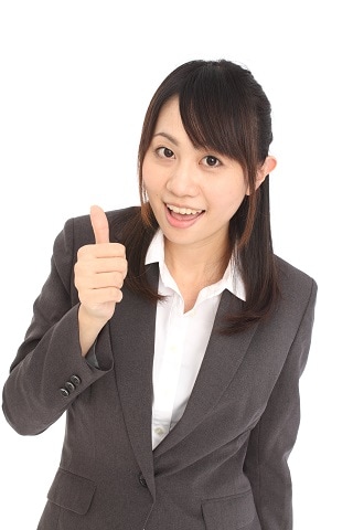 親指を立てているスーツ女性