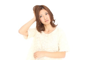 頭をかいている女性