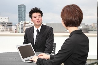 テーブルで話すスーツ男女