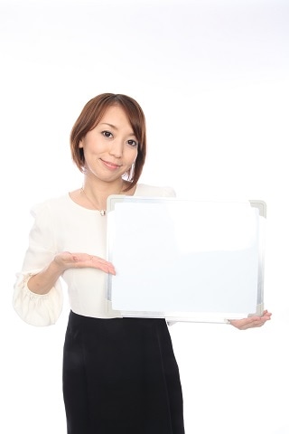 ホワイトボードで案内する女性