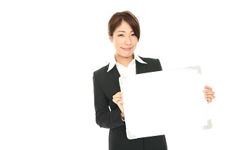 ボードを手にするスーツ女性