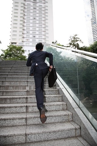 階段を走るスーツ男性