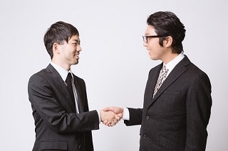 握手をしているスーツ男性