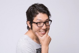 あごを押さえるメガネの男性