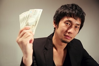 お金をこちらに見せている男性