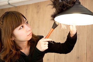 照明カバーをきれいにしている女性