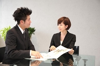 テーブルで男性に説明している女性