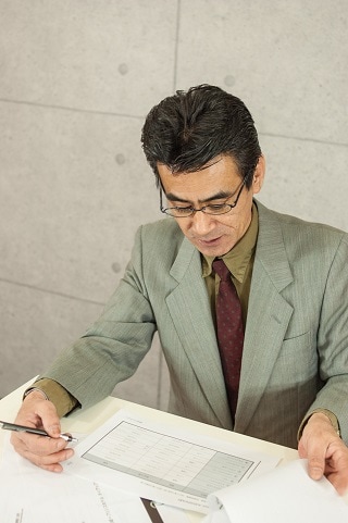 資料を見るスーツ男性