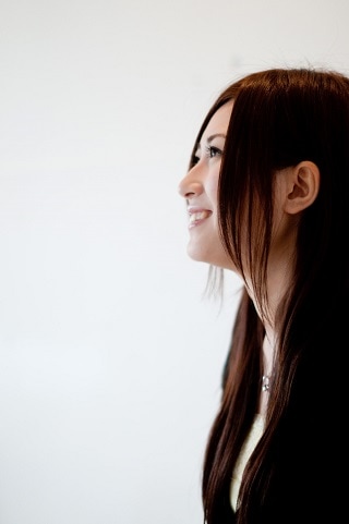 左を向いて笑っているスーツ女性