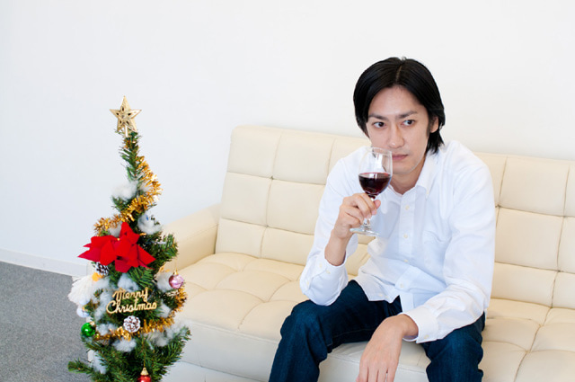 ソファで座ってワインを飲む男性