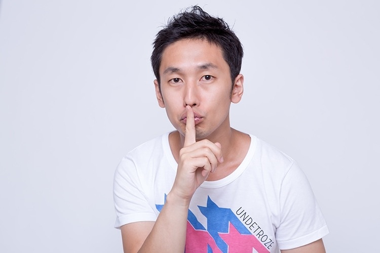 しーっというジェスチャーをしている男性