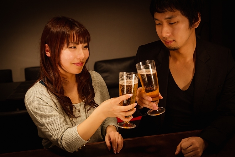バーで乾杯している男女