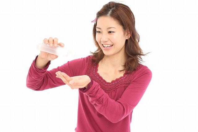 手に薬を出している女性