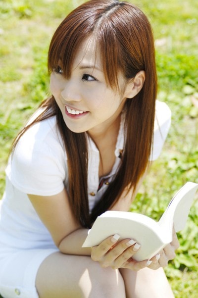外で本を読んでいる女性