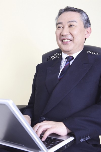 パソコンをするスーツのおじさん