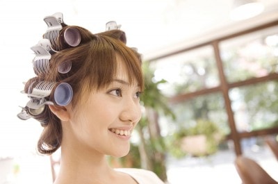 ヘアサロンでパーマをあてる女性