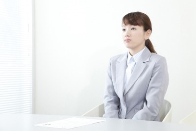 いすに座っているスーツ女性