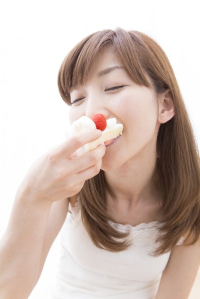 ケーキにかぶりつく女性