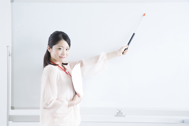 ホワイトボードでプレゼンをしているOL