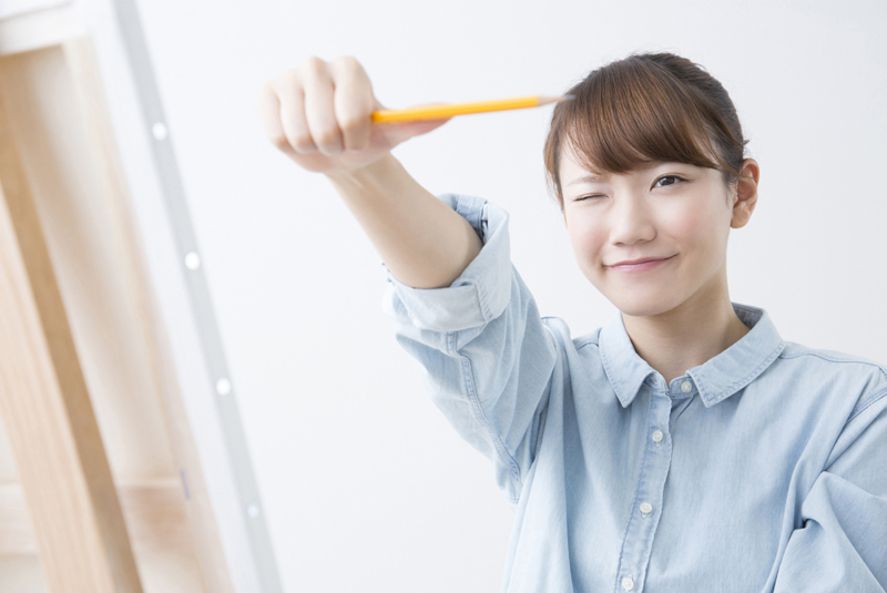鉛筆でサイズを確認している女性