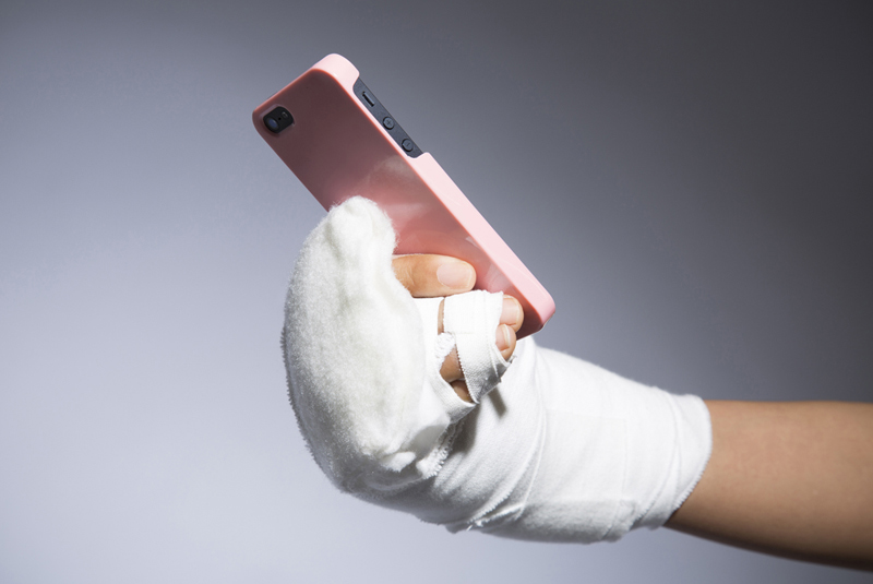 手を折っている人がスマホを持っている