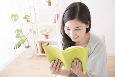 テーブルで本を読む女性