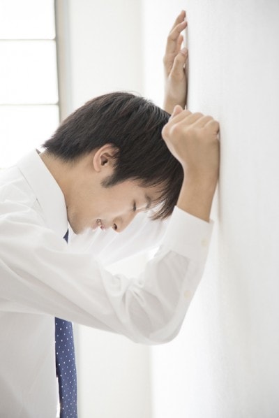 壁にうちひしがれている男性