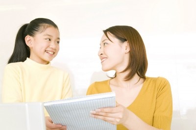 娘に本を見せる母親