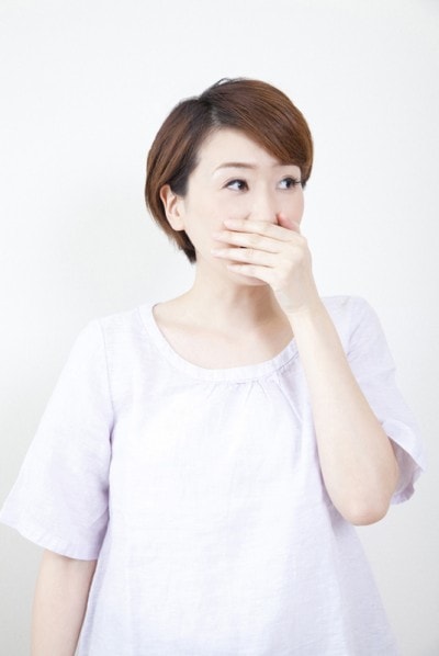 口を押さえる女性