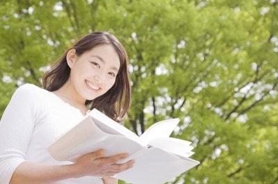 笑いながら本を読む女性