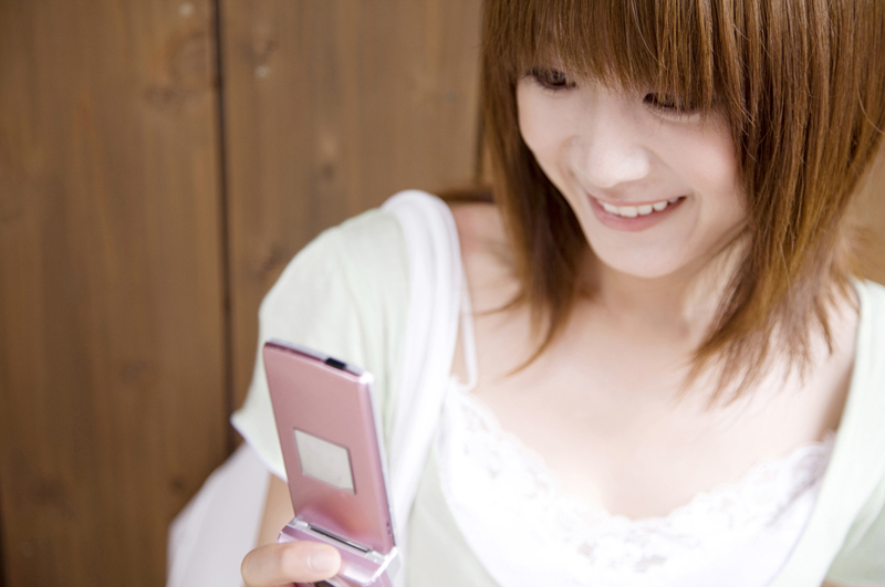 携帯をいじる女性