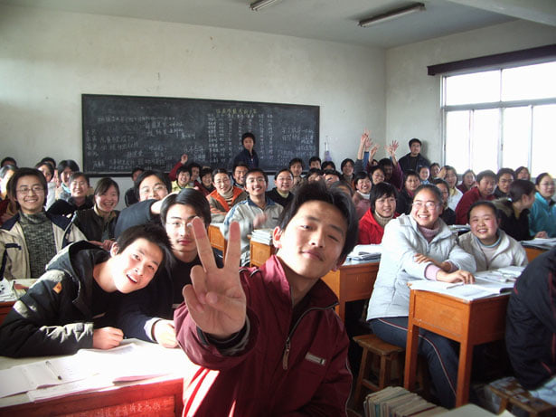 教室でピースをしている学生