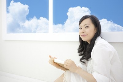 窓際で本を読む女性