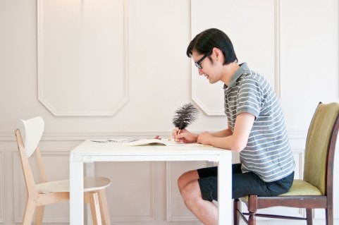 テーブルで日記を綴っている男性