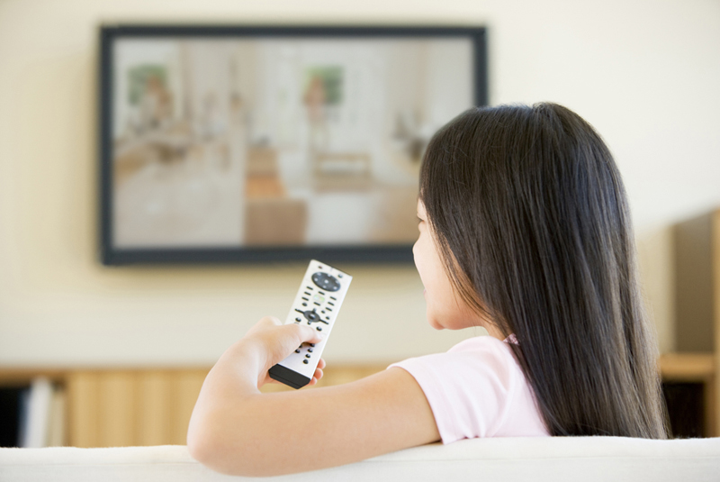 テレビのリモコンをかえる女性
