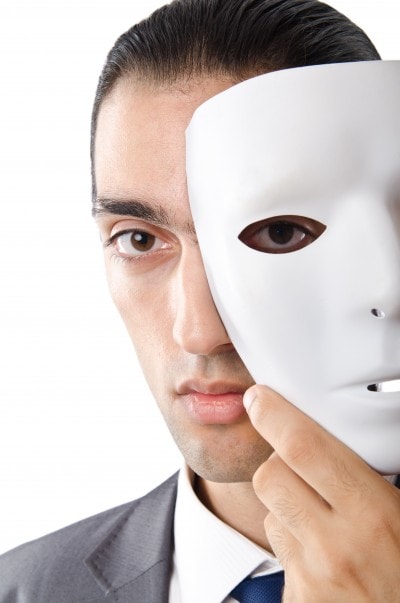 仮面を持っているスーツ男性