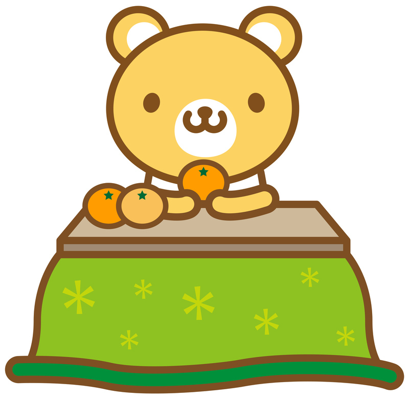 こたつに入ってみかんを食べているクマ