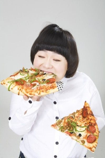大きめのピザを両手に抱えて食べている女性